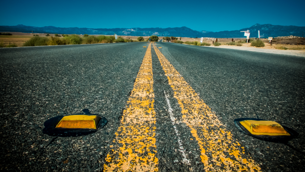 Asphalt road with yellow lines and markers