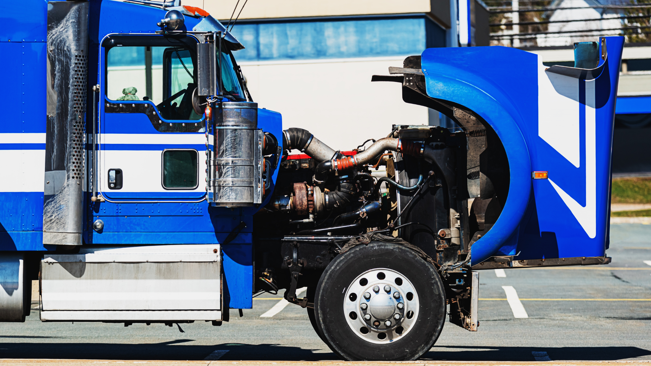 Blue Semi truck with the hood open for an inspection